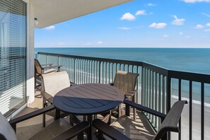 Enjoy ocean views from this balcony with a round table and four chairs.
