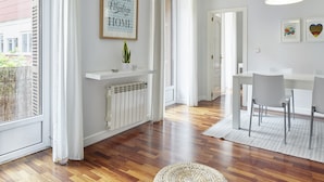 A modern kitchen with a white countertop, a built-in oven, and a window with white curtains. - Always Easy I Escolta Real (San Sebastián/Donostia)