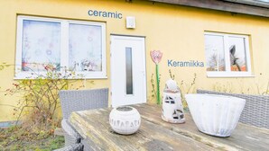 A yellow building with the words "ceramic" and "Keramiikka" on the facade, a door, and windows with artwork. - Nifty Apartment in Rövershagen near Sea (Roevershagen)