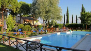 A pool area with lounge chairs and a wooden fence. - Apartment With Swimming Pool in Marsciano (Marsciano)