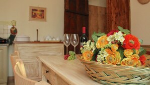 A kitchen with wooden cabinets, a dining table, and a wicker basket with flowers. - Apartment With Swimming Pool in Marsciano (Marsciano)