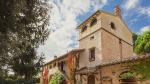 A rustic building with a stone facade, a balcony, and a large window. - Apartment With Swimming Pool in Marsciano (Marsciano)