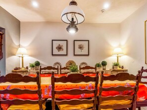 Une chambre à coucher avec un lit en bois, deux lampes fixées au mur et des œuvres d’art florales encadrées.