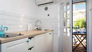A modern kitchen with white cabinets, a stainless steel sink, and a window overlooking a patio area. - Adorable Holiday Home Located Near the Beach (Baska)