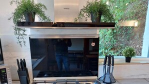 A modern kitchen with a stainless steel stove, oven, and dishwasher, featuring a built-in microwave and knife block. - Modern Holiday Home with Hot Tub & Sauna in Ardennes (Lierneux)