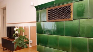 A room with a green tiled wall, a wooden table, and a plant. - Mountain Biker's Farmstay (Villingen-Schwenningen)