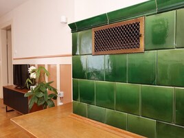 Una habitación con pared de azulejos verdes, una mesa de madera y una planta.