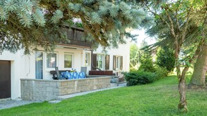 A house with a stone patio, outdoor seating, and a well-maintained lawn. - Mountain Biker's Farmstay (Villingen-Schwenningen)