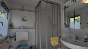 A bathroom with a toilet, sink, and shower. - Bootshaus Direkt am See mit Eigenem Steg an der Ostsee (Sternberg)