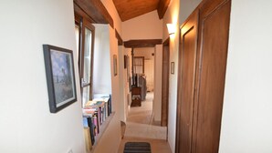 A narrow hallway with wooden beams on the ceiling, a patterned rug, and a door on the right. - Apartment in Pennabili on Tuscan Border near Nature Park (Pennabilli)