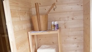Een houten plank met een houten emmer, twee flessen en een opgevouwen handdoek.