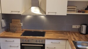 Een moderne keuken met een houten aanrecht, roestvrijstalen apparatuur en een inbouwoven.