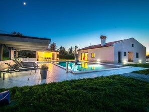 A modern house with a swimming pool, outdoor seating, and a well-lit patio area. - Beautiful Villa in Vrsar With Swimming Pool (Vrsar)