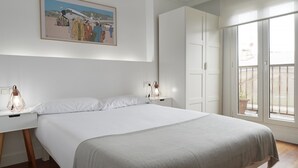 A bedroom with a large bed, white walls, a framed picture above the bed, and a balcony with a view. - Always Easy I San Martin (San Sebastián/Donostia)