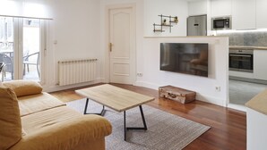 A modern living room with a sofa, a coffee table, and a flat-screen TV. - Always Easy I San Martin (San Sebastián/Donostia)