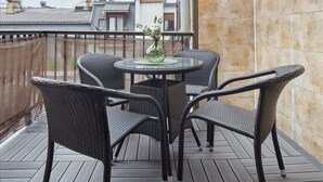 A balcony with wicker furniture, a glass table, and a vase with greenery. - Always Easy I San Martin (San Sebastián/Donostia)