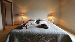 A bedroom with a large bed, two bedside lamps, and a wooden ceiling. - Unique Holiday Home in Virton with Hot Tub (Habay)