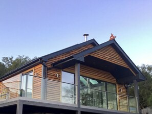 A modern building with a wooden exterior, large windows, and a balcony. - Tidereach - Otters View - UK12269 (Connel, near Oban)