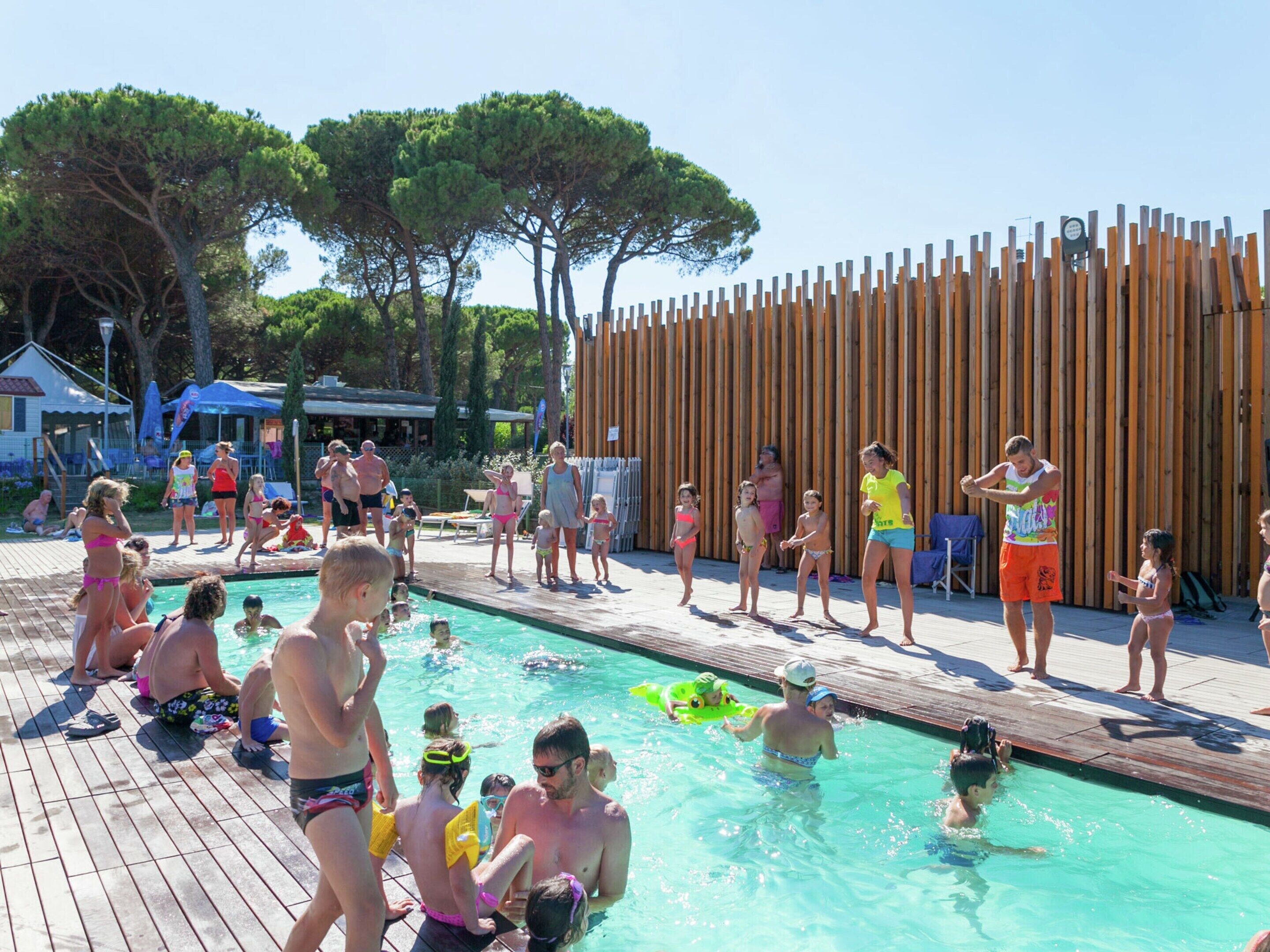 Une zone autour d’une piscine où des personnes nagent et se tiennent debout.