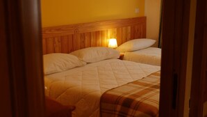 A room with two beds, wooden headboards, and a nightstand with a lamp. - Contemporary Apartment in Breuil-Cervinia near Ski Area (Valtournenche)
