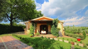 A small, stone house with a tiled porch, surrounded by lush greenery and a clear sky. - Holiday Home in Sabina With Saltwater Pool (Selci)