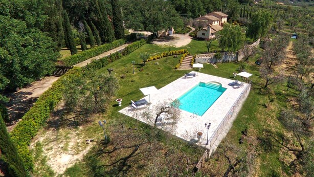 A large rectangular swimming pool surrounded by a well-maintained lawn, with a stone pathway leading to a building. - Holiday Home in Sabina With Saltwater Pool (Selci)