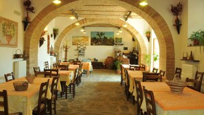 An interior with arched brick ceilings, tables with orange tablecloths, and chairs. - Holiday Home Monte With Pool and Forest Trails (Monte Santa Maria Tiberina)