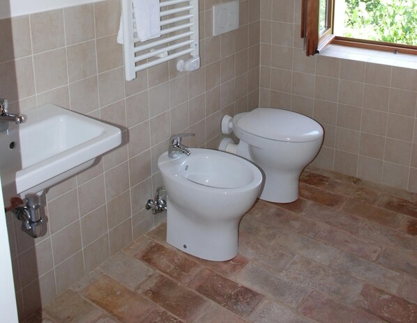 A bathroom with a sink, bidet, and toilet. - Belvilla by OYO Lisa Fonte Parolla (Terre Roveresche)