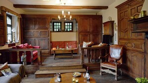 A traditional room with wooden furniture, a chandelier, and a dining area with a table set for two. - Spacious Villa in Liege (Spa)