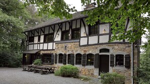 A traditional half-timbered building with a gravel driveway and a picnic table. - Spacious Villa in Liege (Spa)