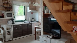 A cozy cabin interior with a kitchen, dining area, and a staircase.
