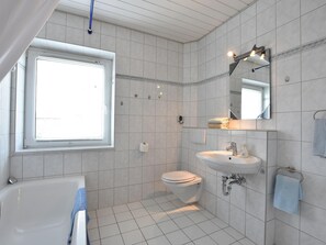A modern bathroom with a bathtub, toilet, and sink. - Tolles Ferienhaus in Wismar fur 8 Personen (Wismar)