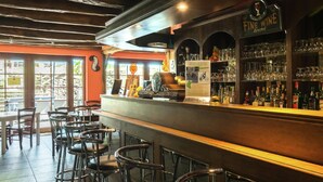 A bar area with stools, a counter, and a wine sign. - Quaint Apartment in Sensenruth With Terrace (Bouillon)