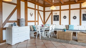 A dining area with a wooden ceiling, white furniture, and decorative wall art. - Gouvy Getaway Holiday Home (Gouvy)