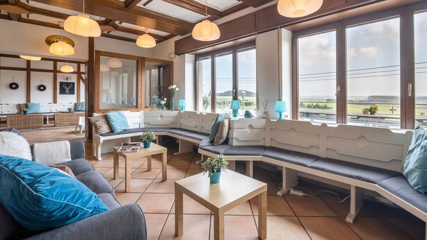 A spacious living area with a large window, wooden ceiling, and a seating arrangement. - Gouvy Getaway Holiday Home (Gouvy)