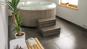 A modern bathroom with a freestanding bathtub, a potted plant, a wooden bench, and a window with a view. - Secluded Holiday Home with Hot Tub in Kozji Vrh (Cabar)