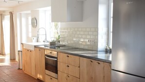 A modern kitchen with wooden cabinets, a stainless steel refrigerator, and a tiled backsplash. - Peaceful Holiday Home (Rochefort)