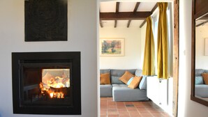 A living room with a fireplace, a sofa with cushions, and a tiled floor. - Peaceful Holiday Home (Rochefort)