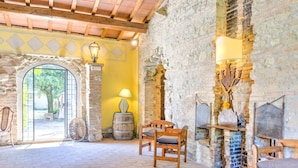 Un interior rústico con paredes de piedra, muebles de madera y una chimenea de ladrillo.