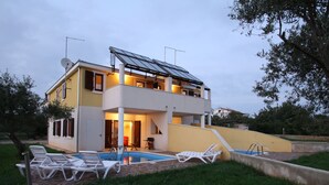 A two-story house with a swimming pool, solar panels, and outdoor seating. - Holiday Home in Novigrad With Private Pool (Novigrad)