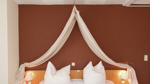 A bedroom with a canopy bed, two bedside lamps, and a wooden nightstand. - Classy Holiday Home in Deutschneudorf near Glockenwanderweg (Deutschneudorf)
