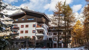 A multi-story hotel with balconies, a ski lift, and snow-covered mountains in the background. - Near the Ski Lifts (Valtournenche)