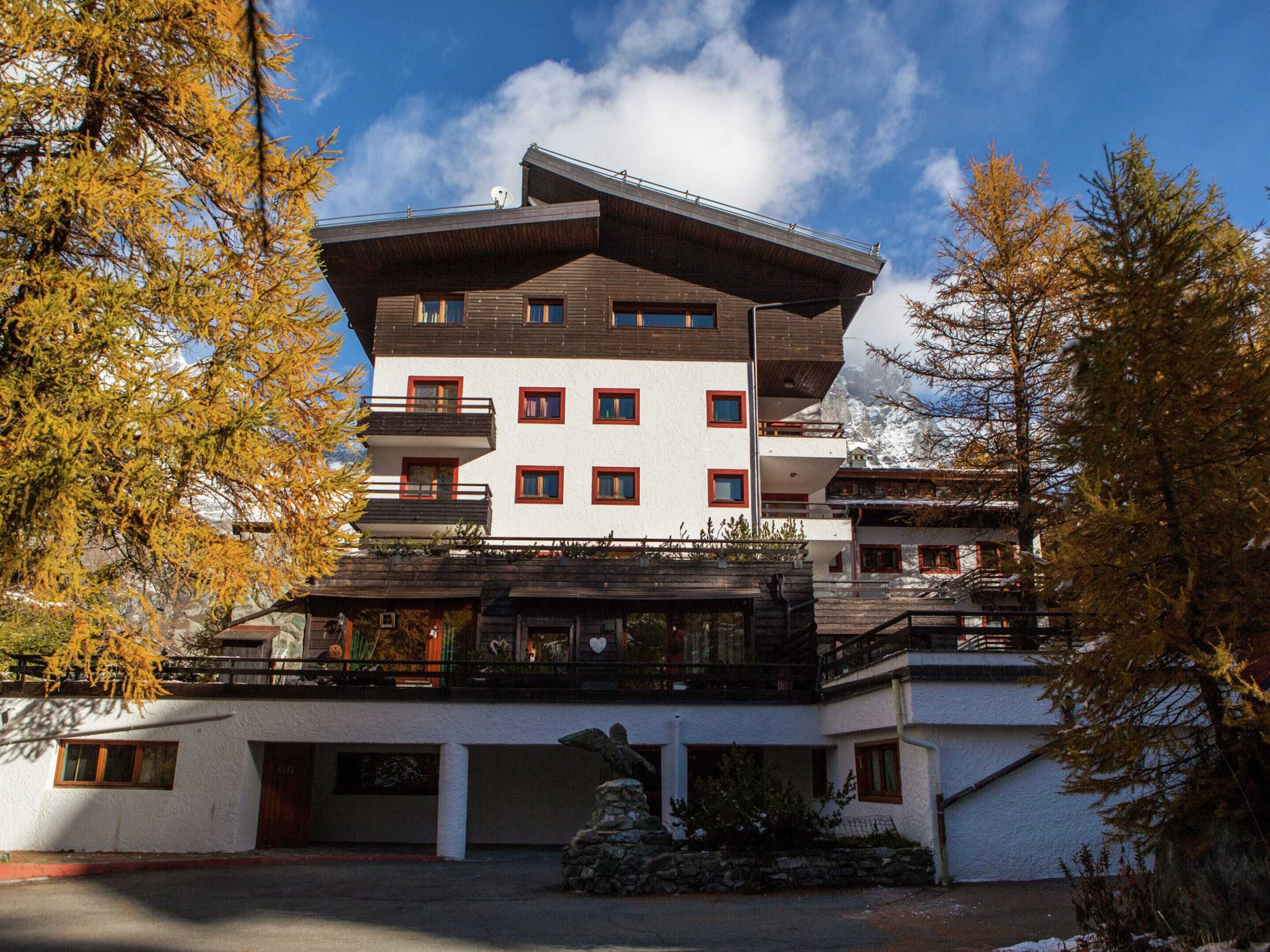 Un hotel a più piani con un design architettonico moderno, caratterizzato da balconi e una facciata in pietra.