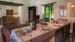 A dining area with a long table set for six, surrounded by wooden chairs. A wooden cabinet and a tripod stand are visible in the background. - Farmhouse in Umbertide Near Lake Trasimeno (Umbertide)