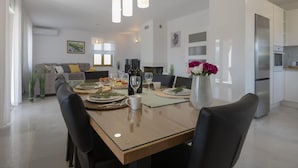 Un comedor moderno con una mesa de madera, sillas negras y un jarrón de flores.