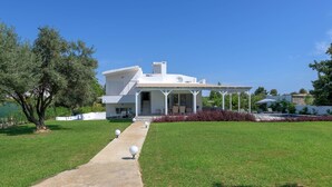 A modern two-story house with a covered patio and a concrete pathway leading to the entrance. - Casa Bianca Villa in Kolympia (Kolympia)