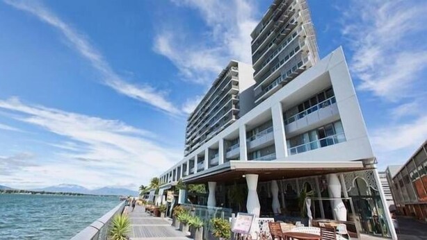 Een modern hotel met uitzicht op het water, met balkons en buitenterrassen.