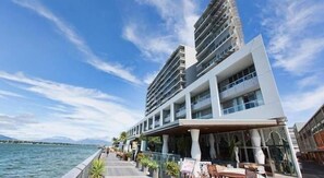 Un hôtel moderne offrant une vue sur le front de mer, doté de balcons et d’espaces de détente en plein air.