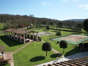 A tennis court with a pavilion, a pool, and a well-maintained lawn. - Farmhouse in Bucine With Pool (Bucine)