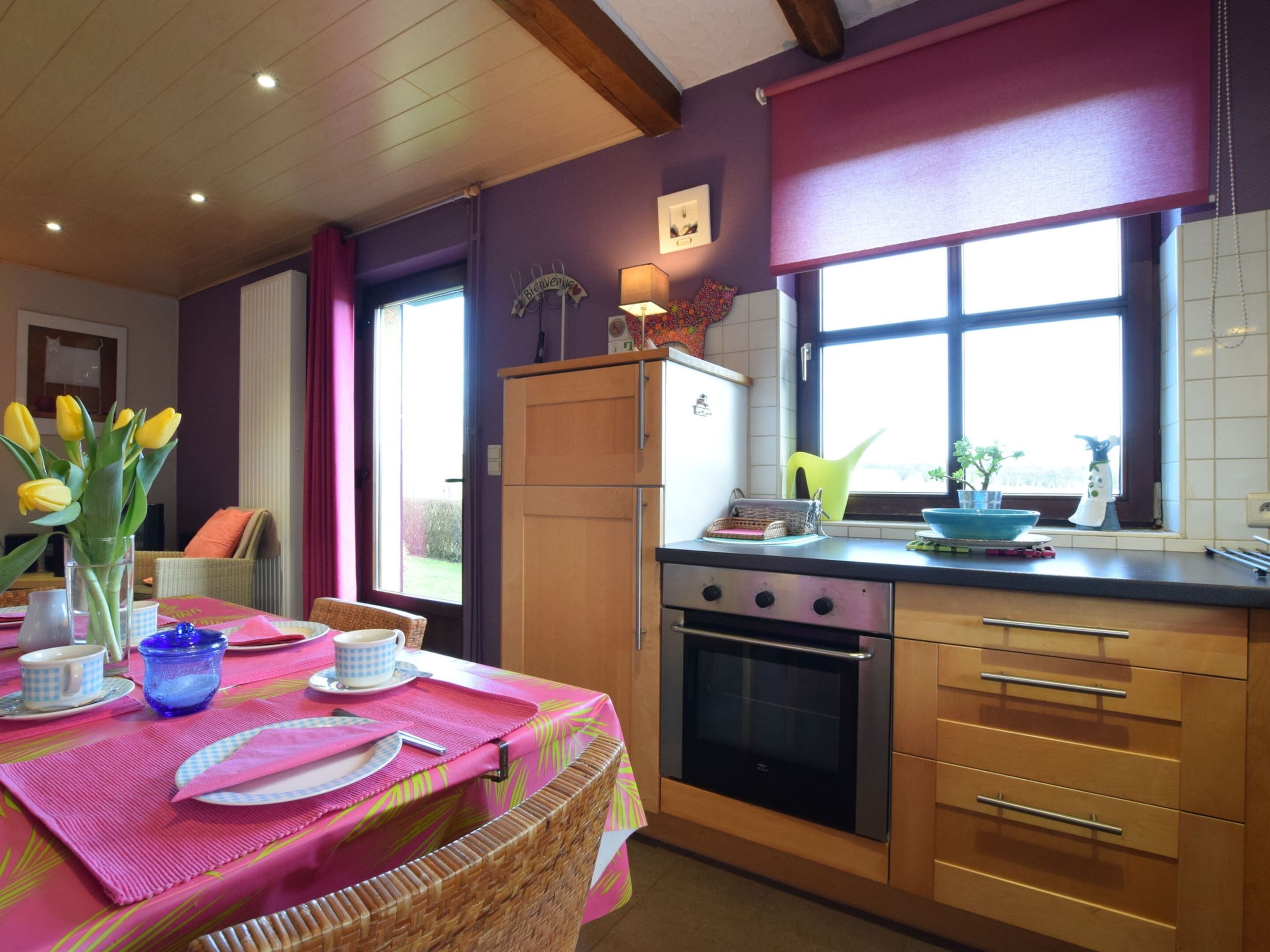A kitchen with wooden cabinets, a built-in oven, and a window with a view.